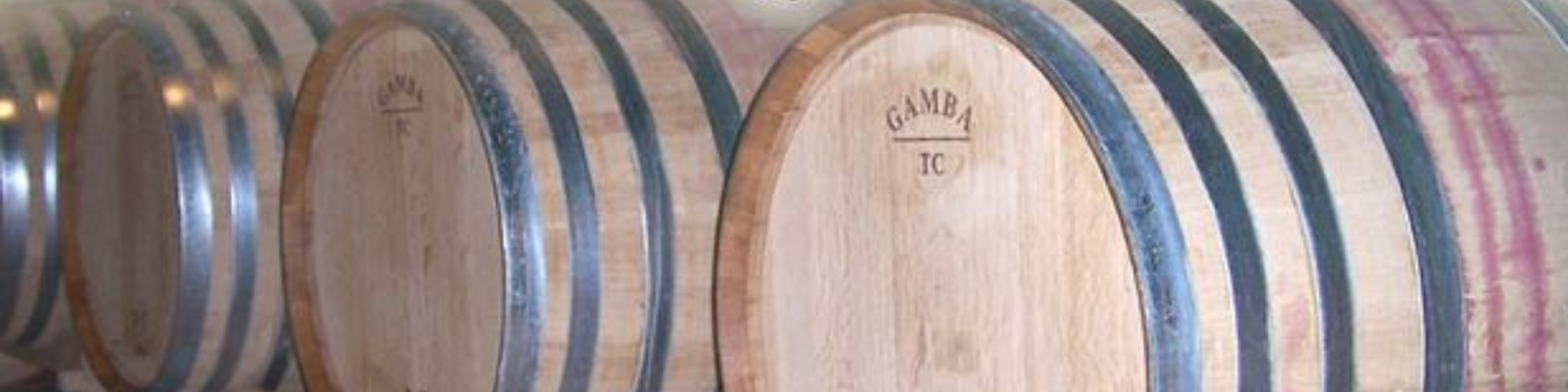 Immagine carosello di botti di rovere in una cantina del marchio Baldassarri.